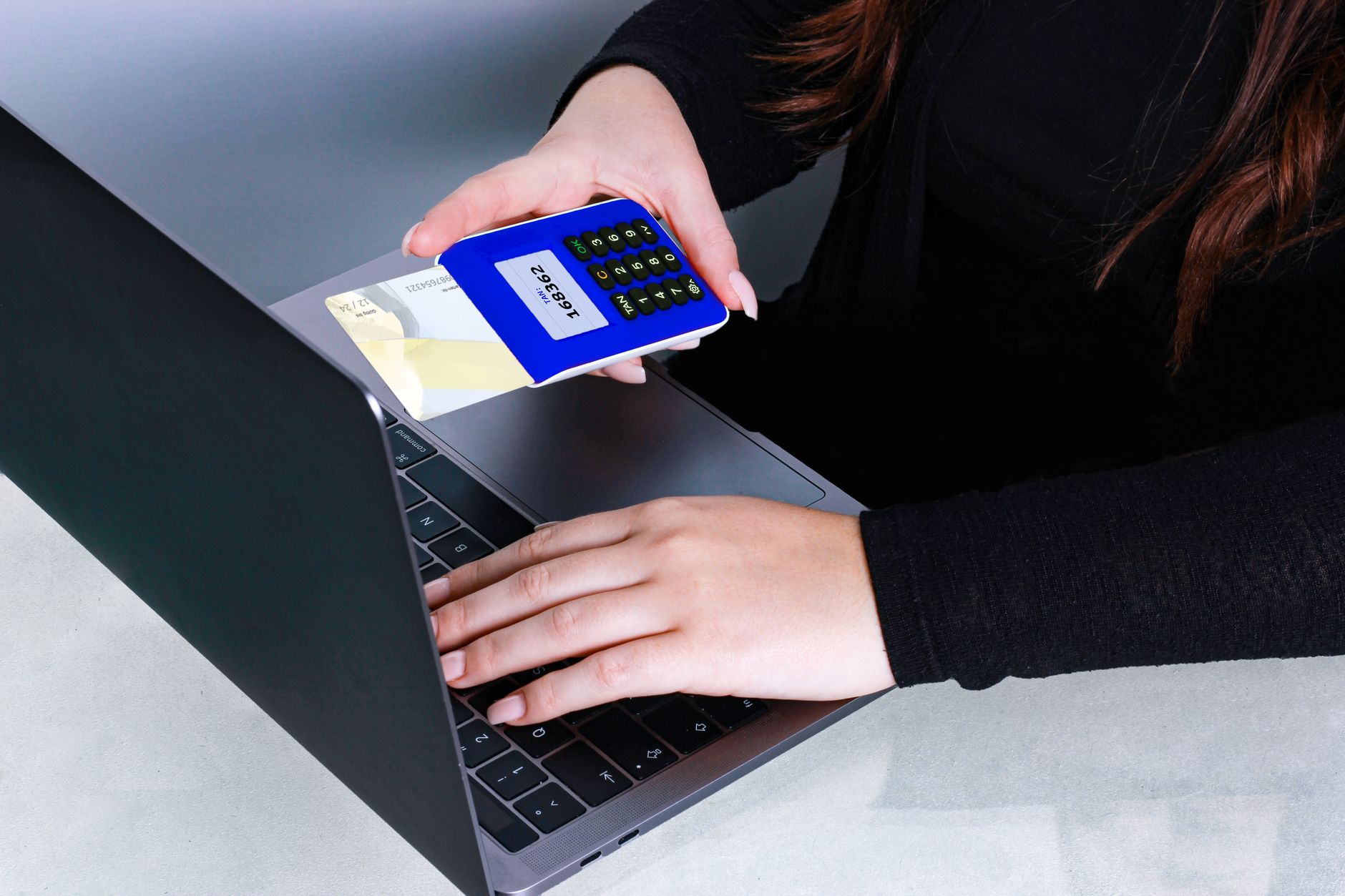 Person using a card reader and laptop for a secure online payment
