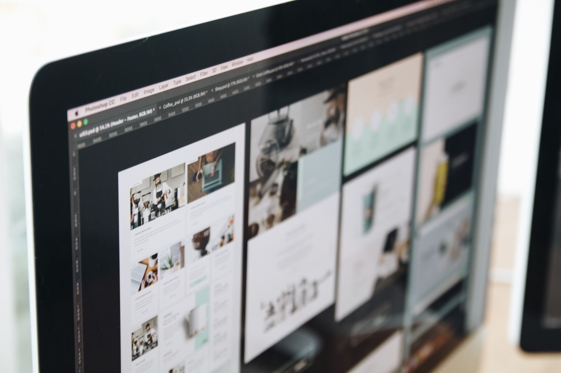 Computer screen displaying a web design project in a modern workspace