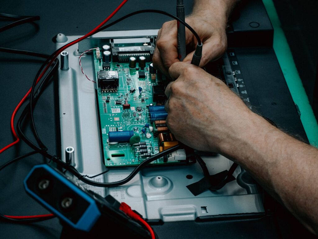 Close-up of hands repairing a circuit board, illustrating careful website maintenance.