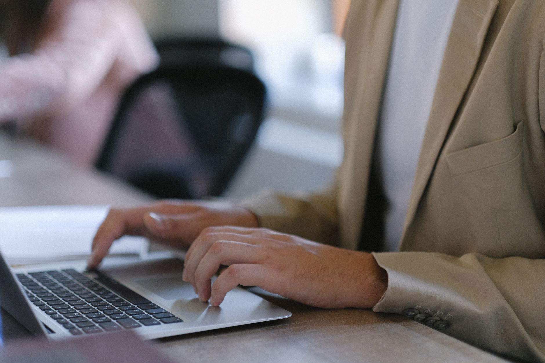 Business professional using a laptop at an office desk
