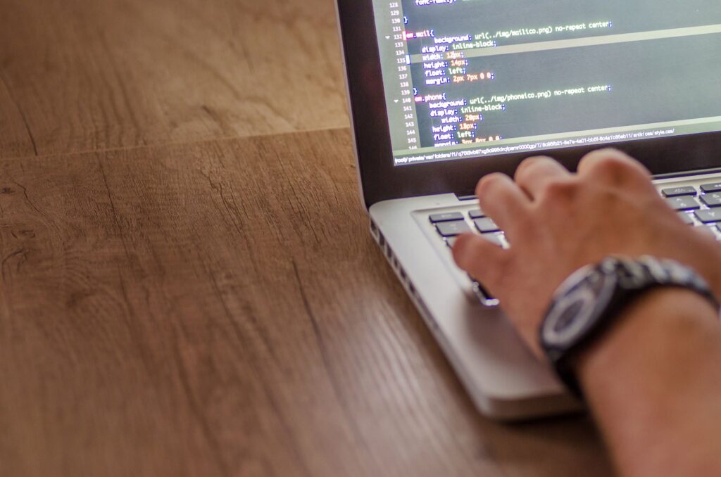 Close-up of a person coding on a laptop for website migration