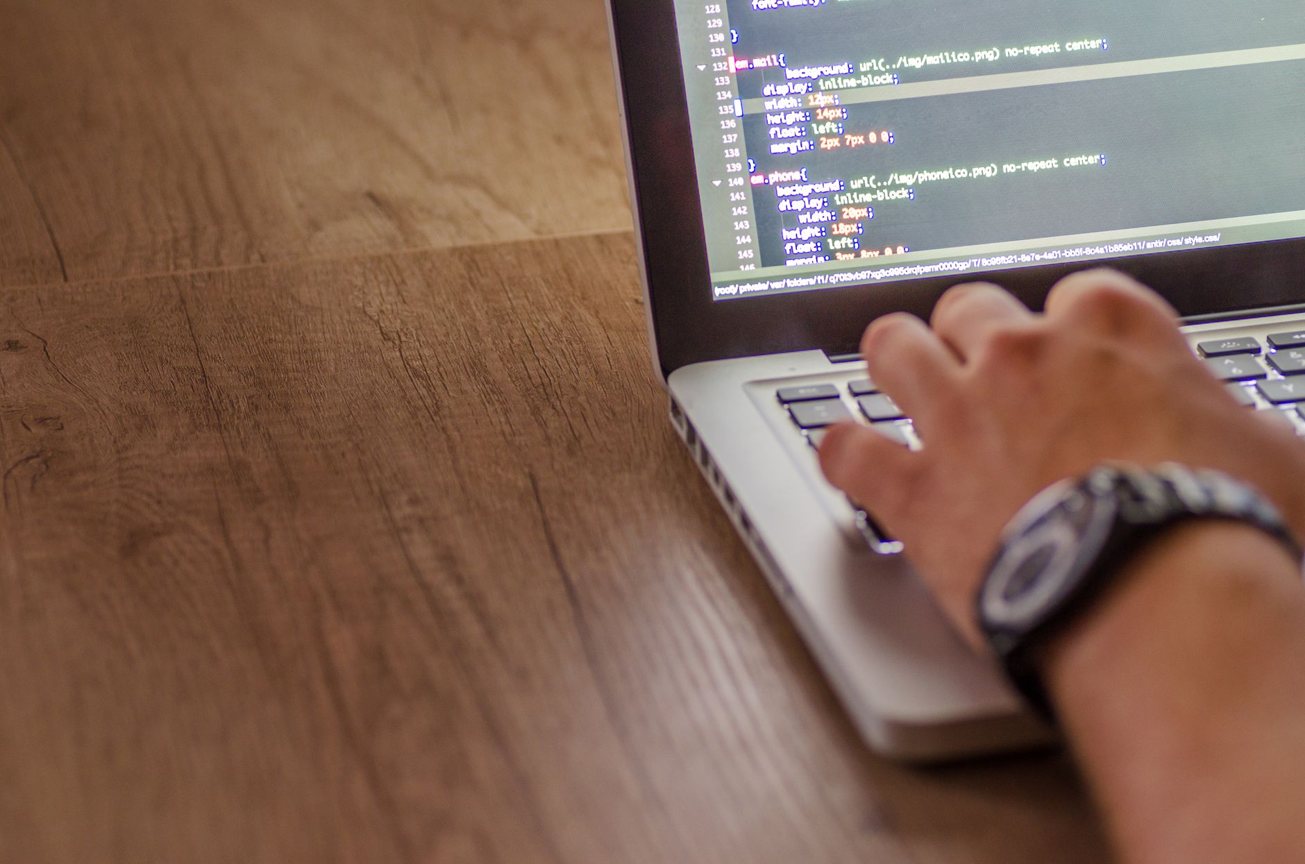 Close-up of a person coding on a laptop for website migration