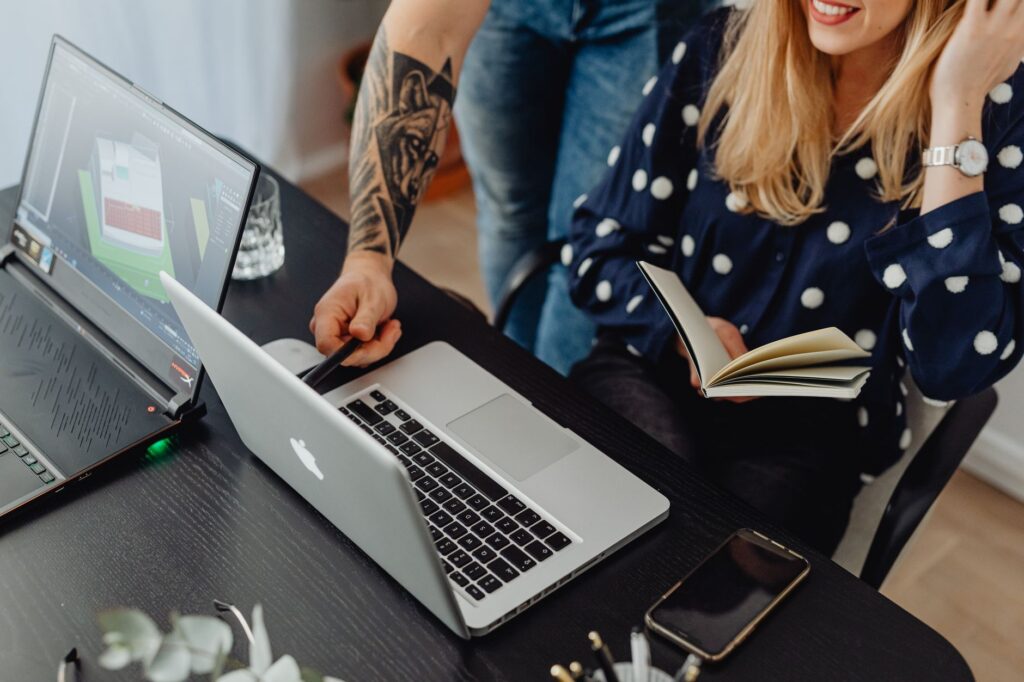 Web design professionals collaborating on laptops in a modern office